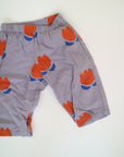 Lila byxor med blommor i orange från Bobo Choses i modell Chocolate Flowers All Over Woven Trousers