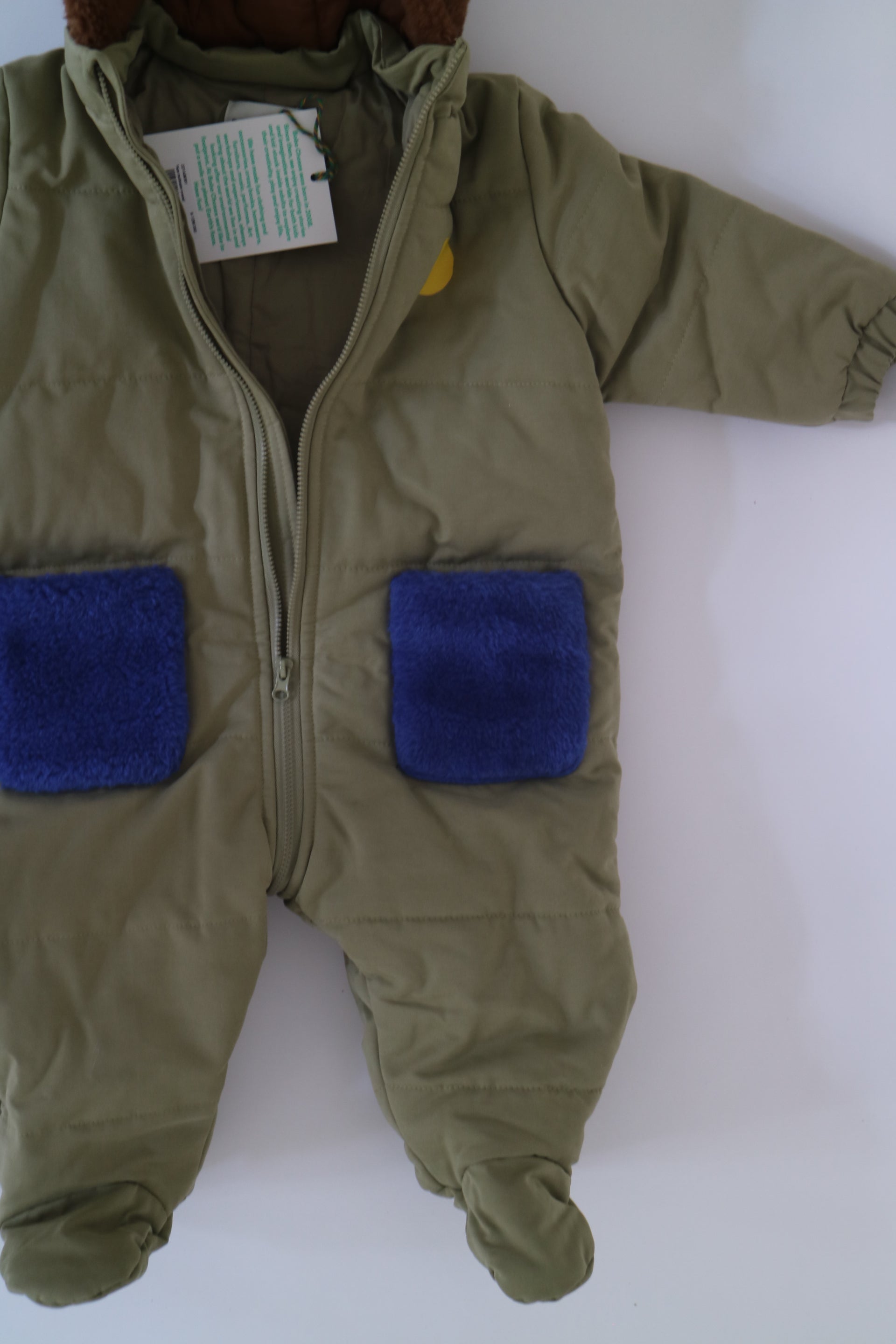 Fodrad overall i ljus militärgrön färg med kornblåa fickor och brun luva i teddy-material från Bobo Choses, modell Face Multicolor Overall. 3