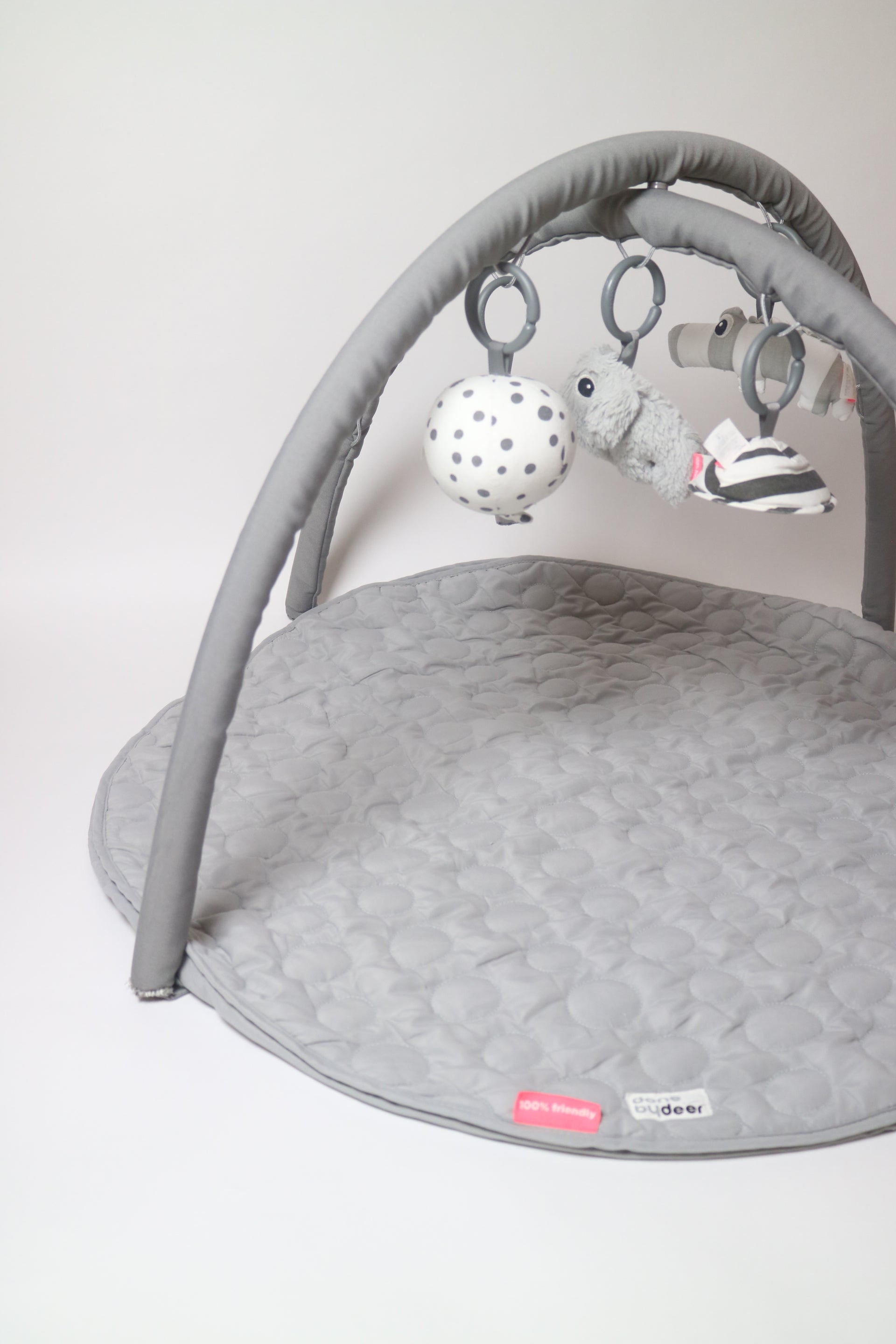 Babygym från Done By Deer i grått. De fem tillhörande leksakerna kan hängas på flera olika sätt och även användas separat.&nbsp;