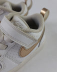 Sneakers från Nike i barnstorlek. Vita, med Nike-logotypen i guld. 