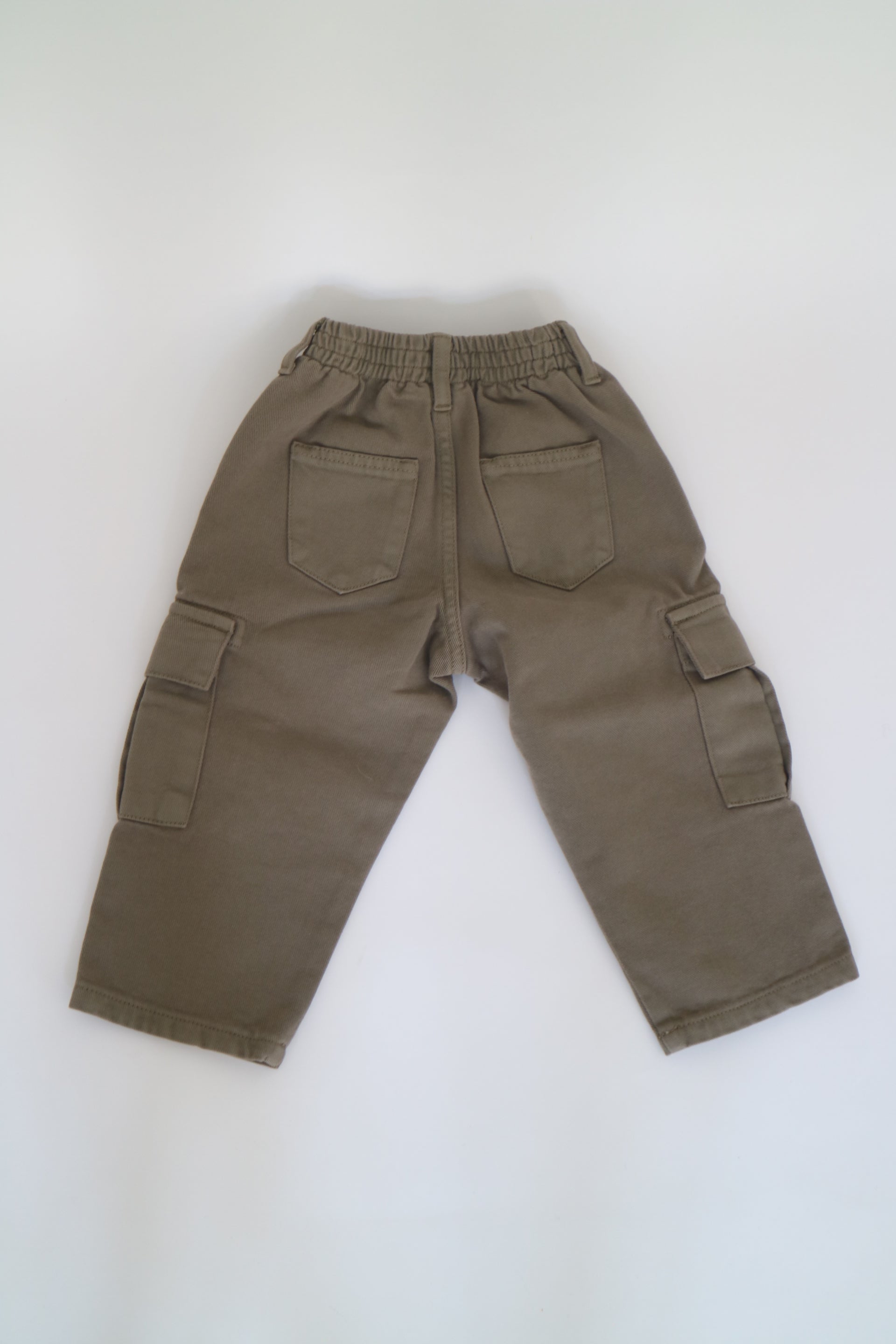 Khakigröna byxor från The New Society av modell Vincent Pant Dried Herb. Cargobyxor med fickor framtill, baktill och längs byxbenen. Byxorna är elastiska i midjan med knapp framtill. Helt nya med prislapp kvar.&nbsp;