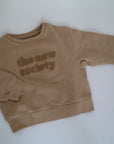 Beige sweatshirt i beige från The New Society, färg Camel. Logo med The New Society i teddy material.&nbsp;