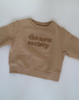 Beige sweatshirt i beige från The New Society, färg Camel. Logo med The New Society i teddy material.&nbsp;